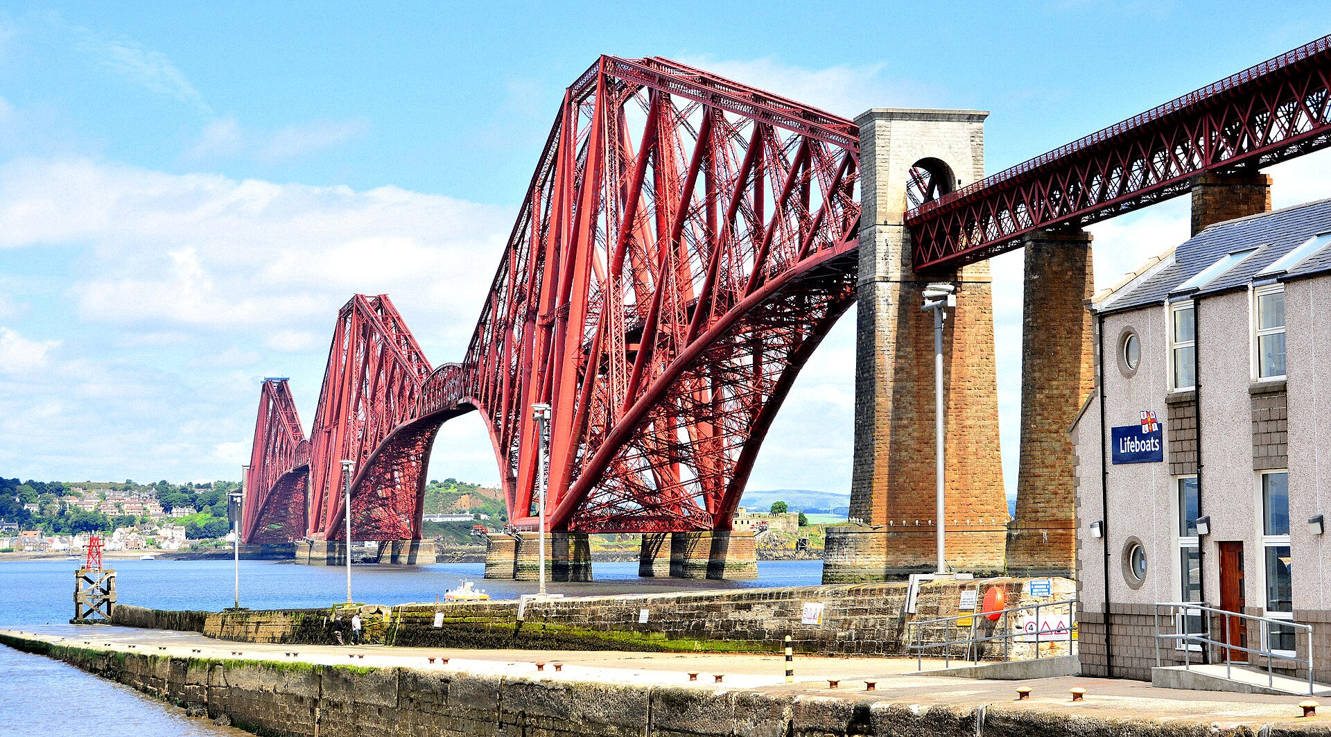 Red steel truss crossing over water